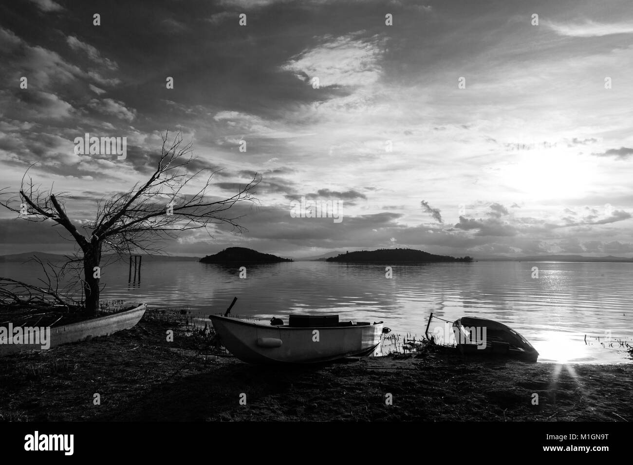 Vue sur un lac au coucher du soleil, presque avec quelques bateaux, d'un vide Banque D'Images