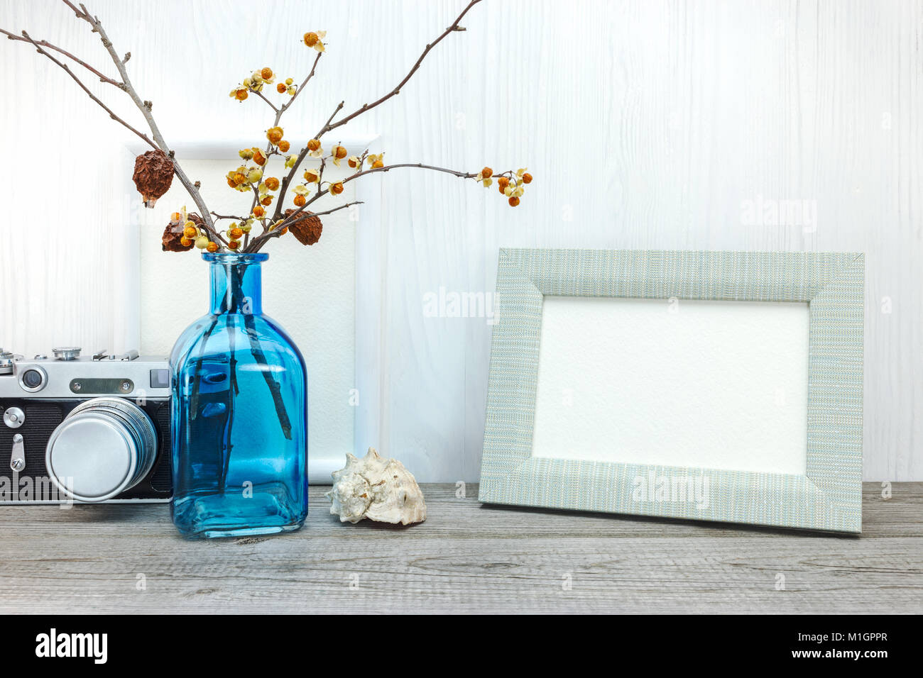 Appareil photo rétro vide, cadre photo, vase avec fleurs séchées sur table en bois Banque D'Images