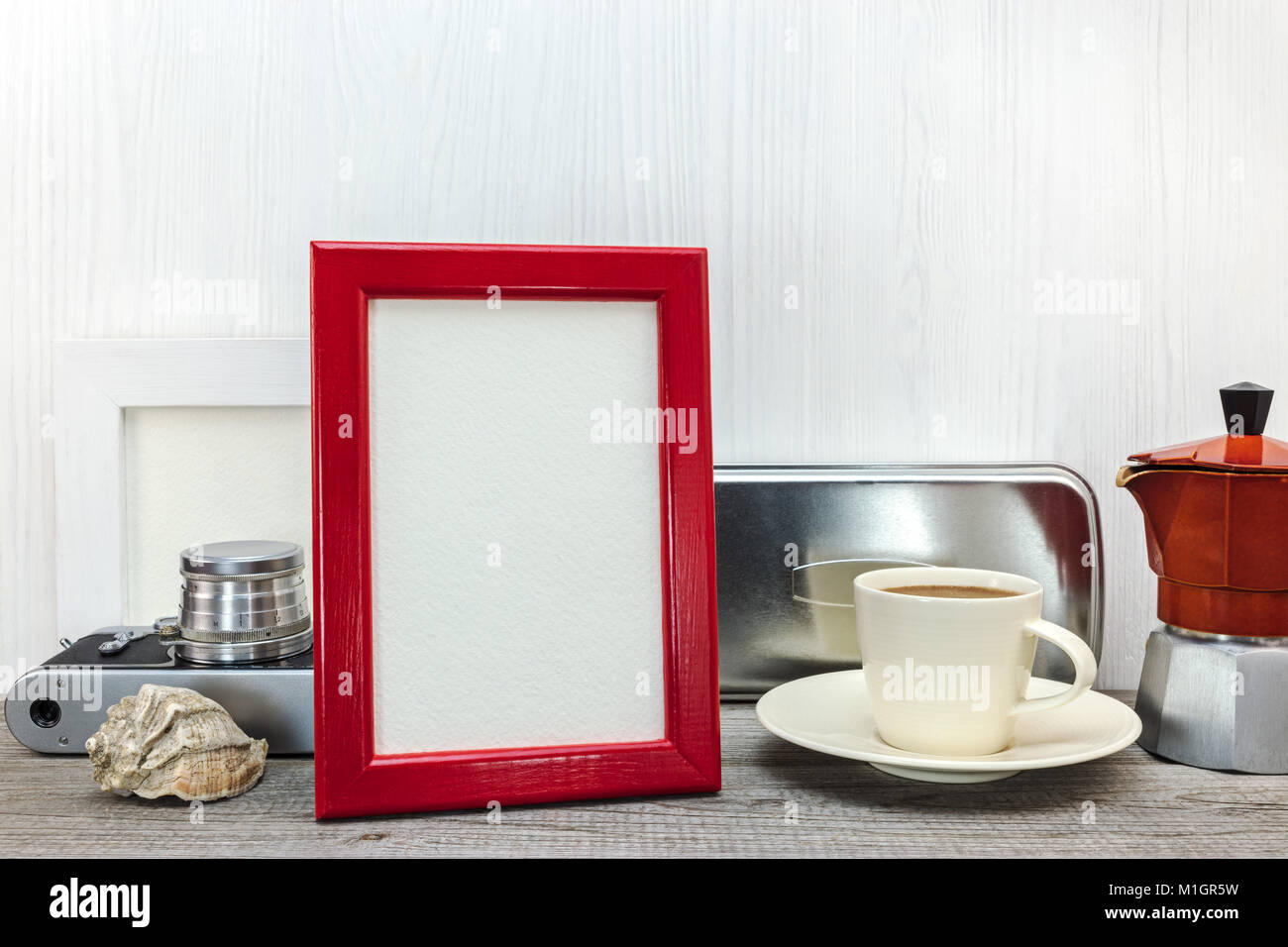 Film ancien appareil photo, cadre photo rouge et cafetière avec tasse sur fond de bois blanc Banque D'Images