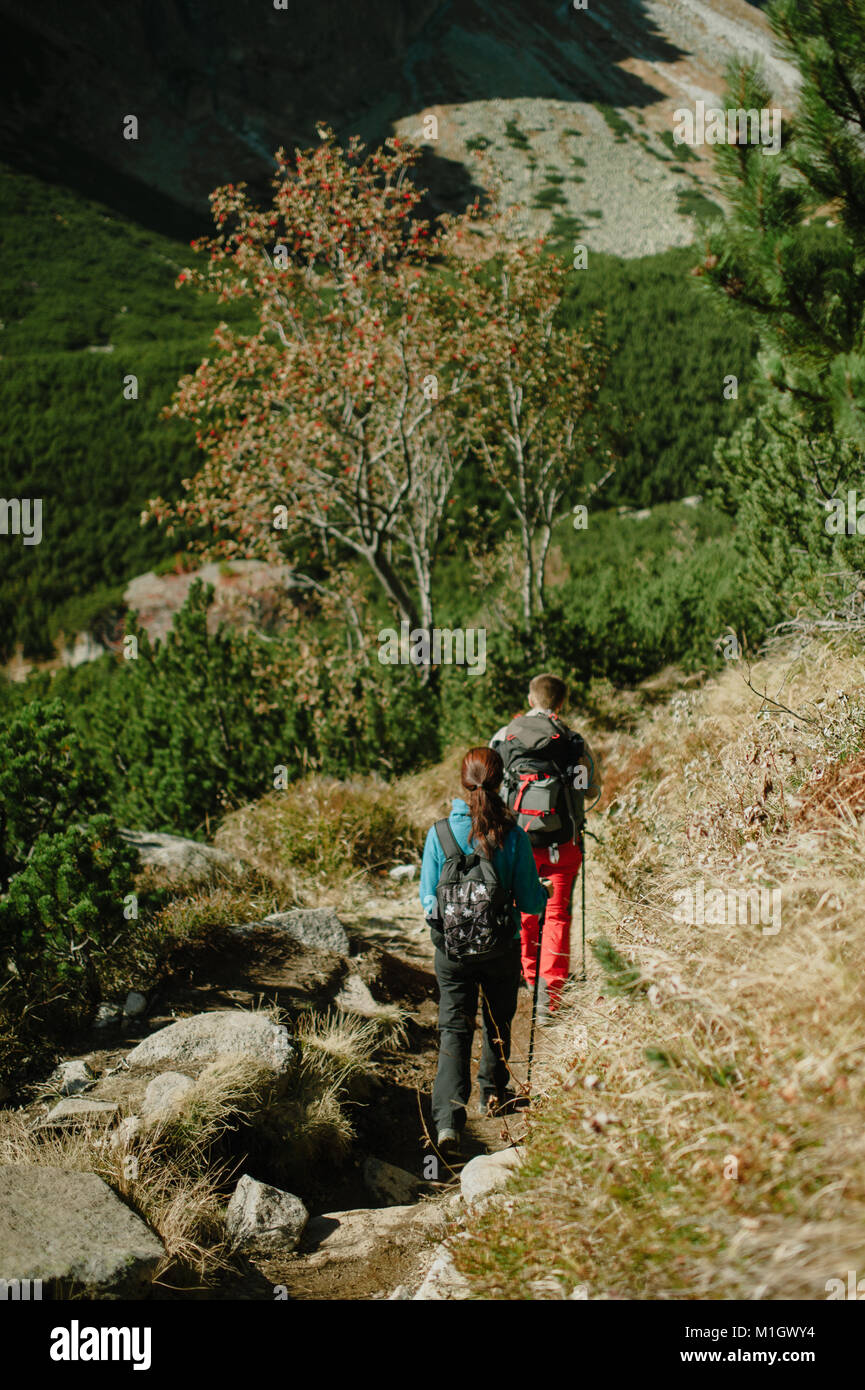 Jeune couple marche nordique dans les montagnes. Banque D'Images