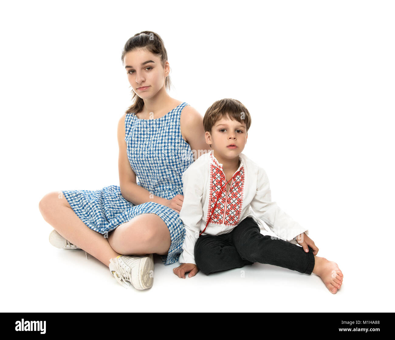 Frère et sœur, studio shot on white. Petit garçon sur la photo porte un t-shirt avec broderie traditionnelle ukrainienne. Banque D'Images