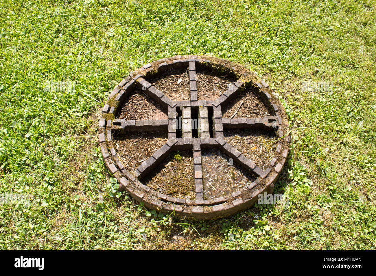 Une vue sur le canal métallique éclosent au milieu de la pelouse. Banque D'Images