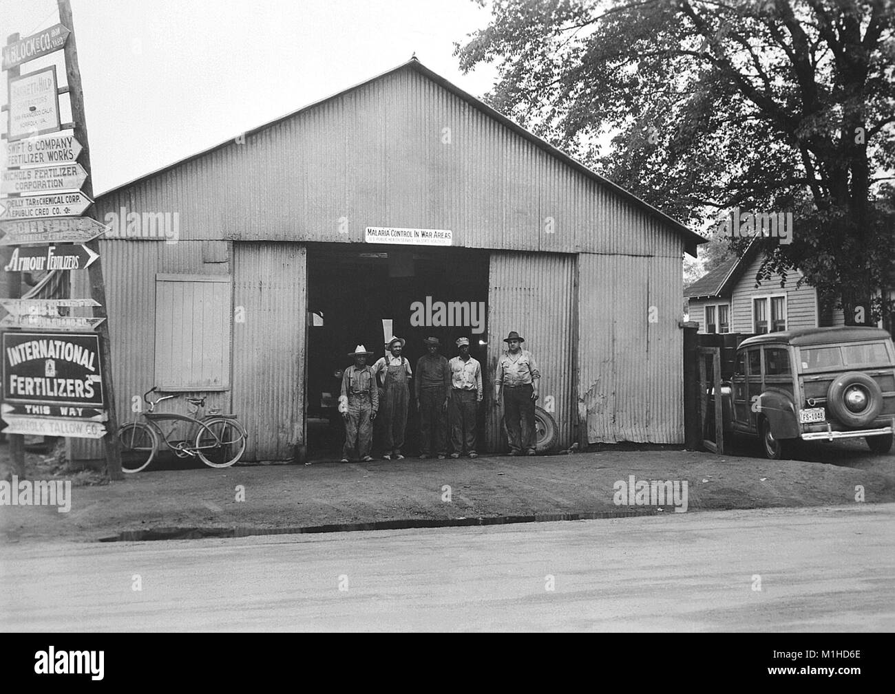 Photographie montrant l'avant d'un bâtiment de l'entrepôt qui servait de bureau local pour la seconde guerre mondiale, l'agence 2 MCWA (lutte contre le paludisme dans les zones de guerre), prédécesseur de la CDC, avec un groupe d'hommes posant devant elle à Savannah, Géorgie, 1943. Image courtoisie CDC. () Banque D'Images