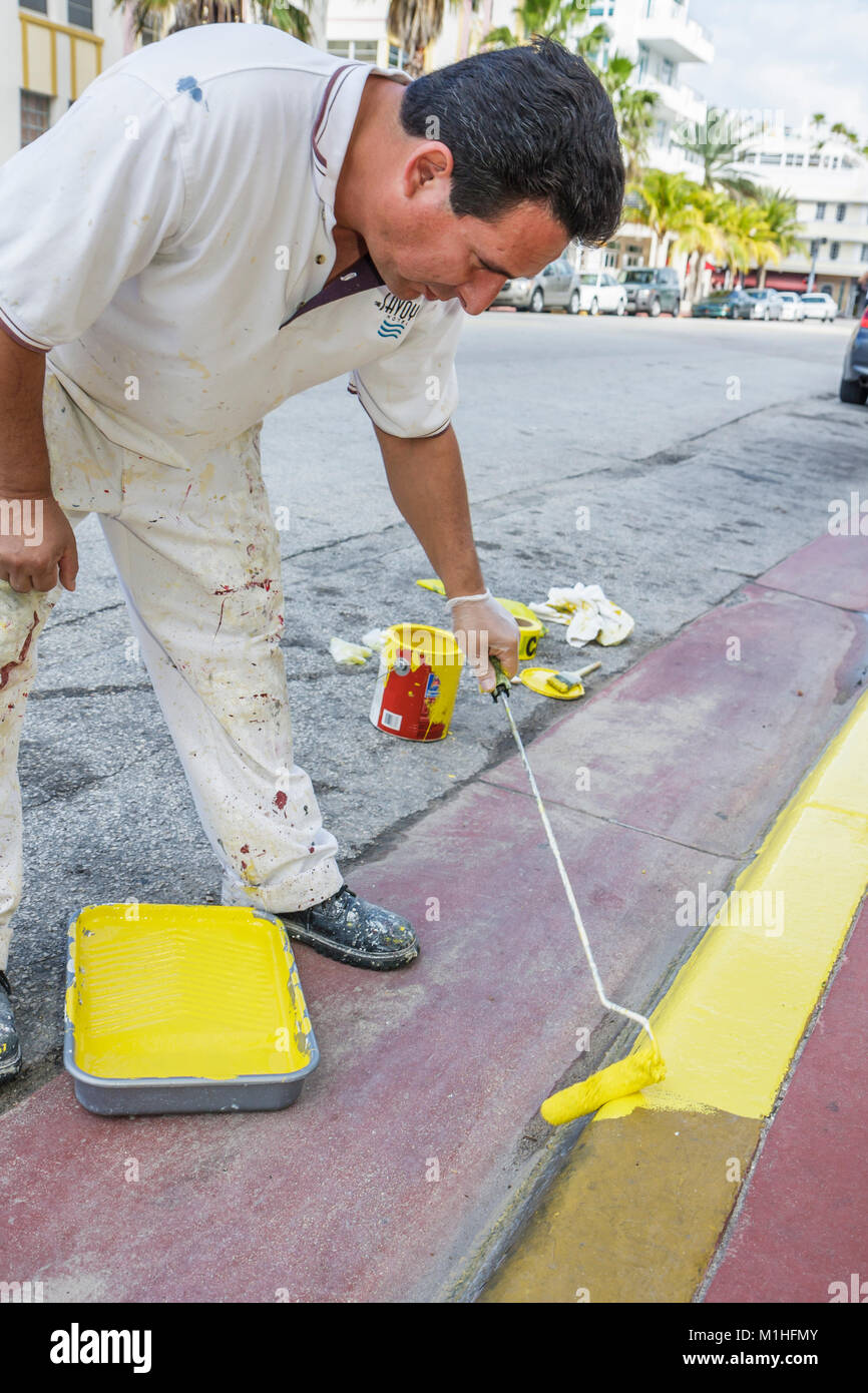 Miami Beach Florida,Ocean Drive,Savoy,hôtel,Hispanic man hommes,travailleur,travailleurs,peintures trottoir,jaune,entretien,travail,travail,travailleurs employés s Banque D'Images
