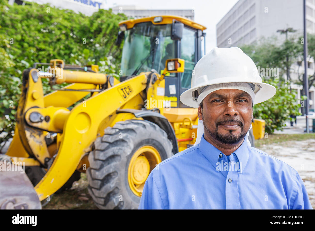 Miami Florida,homme asiatique hommes,casque dur,opérateur de pelle rétro,sous un nouveau chantier de construction, FL080117034 Banque D'Images