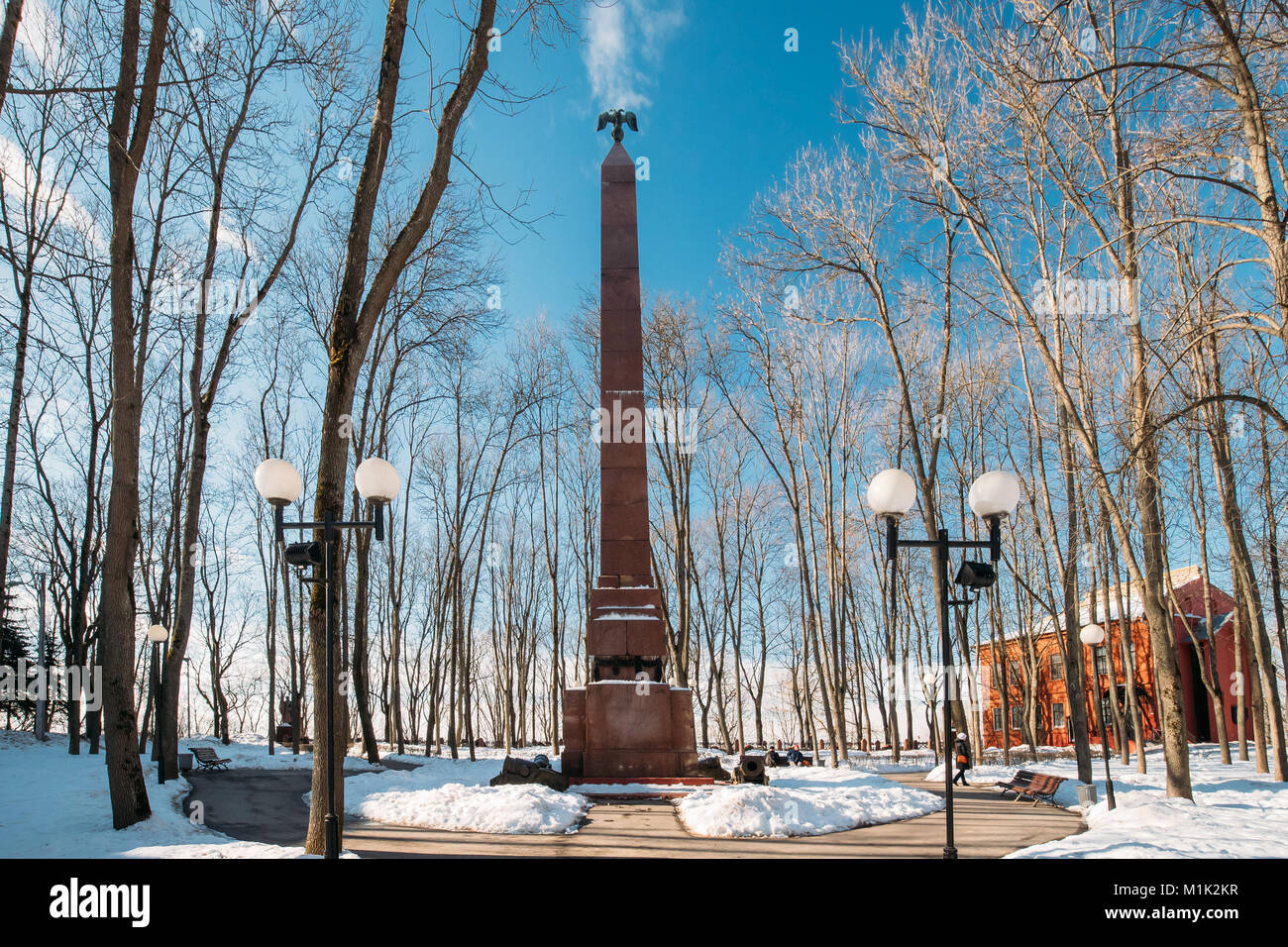 Minsk, Belarus. Obélisque Monument aux héros de la guerre patriotique de 1812 près de palais de gouverneur en hiver journée ensoleillée. Banque D'Images