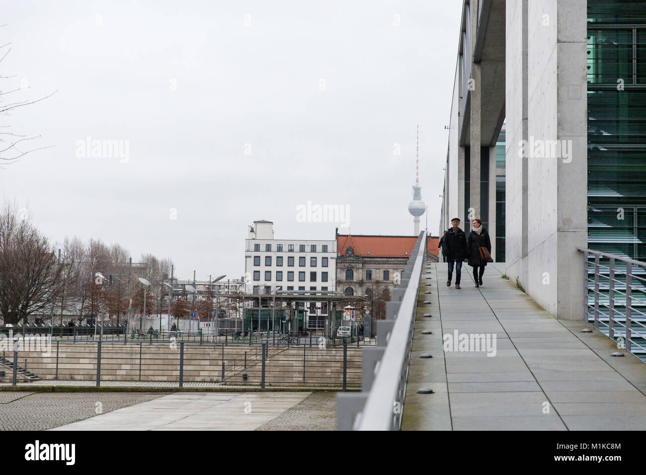 Couple marche sur le pont qui traverse la rivière Spree dans l'Allemand moderne quartier du gouvernement à Berlin Banque D'Images