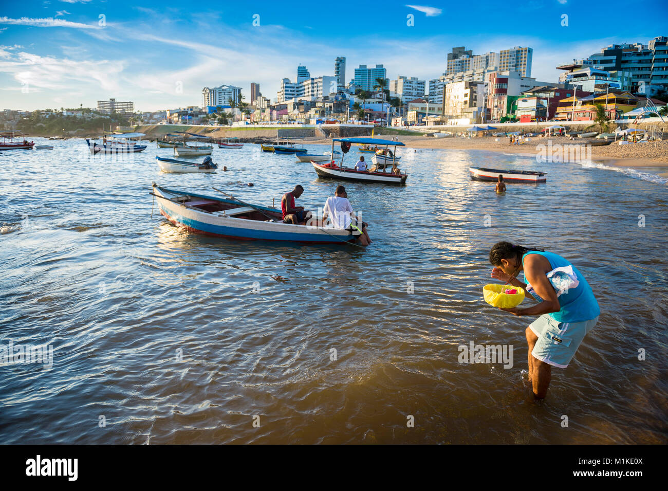 SALVADOR, BRÉSIL - 1 février 2016 : un adorateur au Festival annuel de Yemanja à Rio Vermelho se trouve dans la mer de quitter une offrande religieuse. Banque D'Images