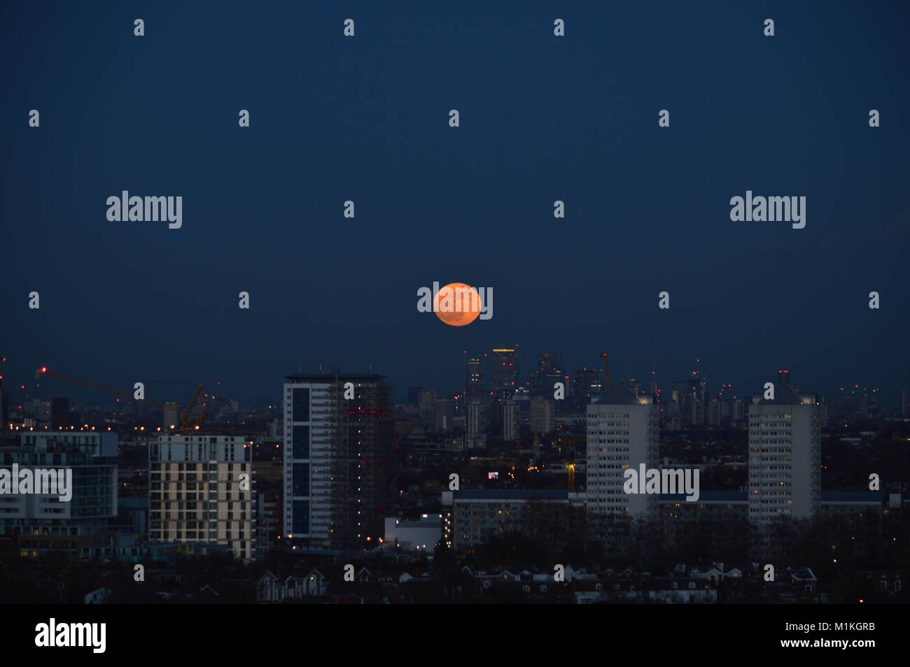 Un super blue blood moon rising sur Canary Wharf, London, UK Banque D'Images