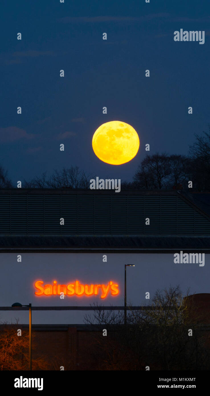 Warwick, Royaume-Uni. 31 janvier, 2018. Le 'super blue' lune se lève plus de supermarché Sainsbury's store à Warwick, Royaume-Uni. Crédit : Colin Underhill/Alamy Live News Banque D'Images