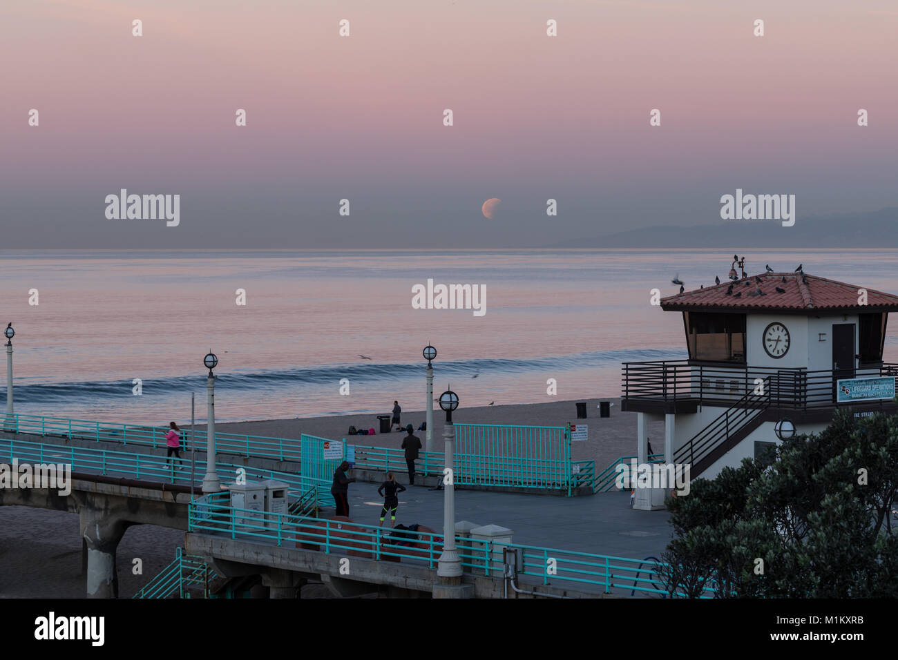 Manhattan Beach, Californie, USA. 31 janvier, 2018. L'offre Super Blue Blood Moon définit comme tôt le matin, les marcheurs et les adeptes de l'oeil sur Manhattan Beach Pier. Credit : Brent Durand/Alamy Live News Banque D'Images