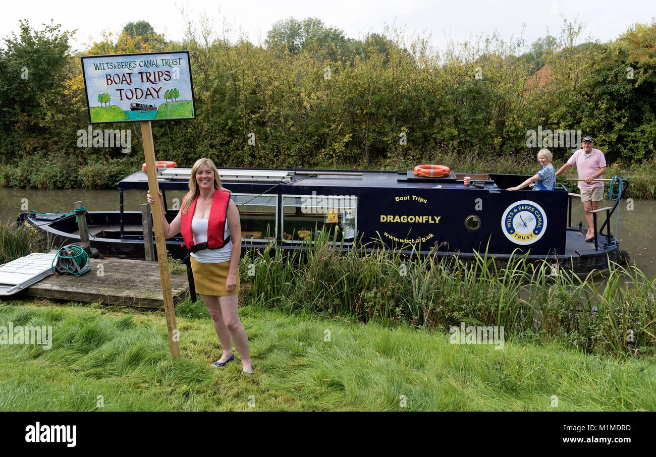 Recherche Femme pour les clients de prendre un bateau à bord d'un grand classique sur l'Wilts & Berks canal près de Swindon UK Banque D'Images