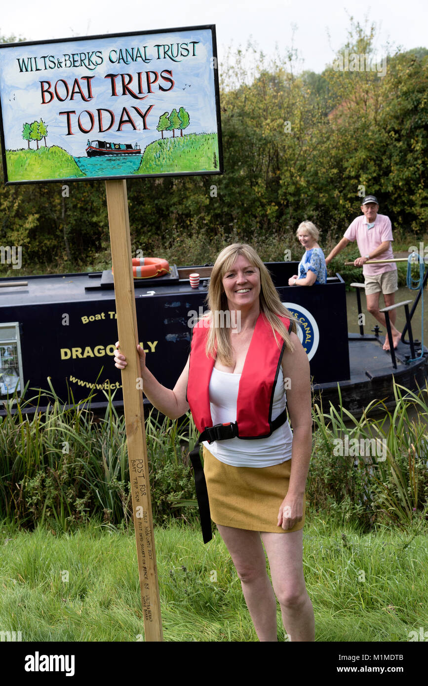 Recherche Femme pour les clients de prendre un bateau à bord d'un grand classique sur l'Wilts & Berks canal près de Swindon UK Banque D'Images