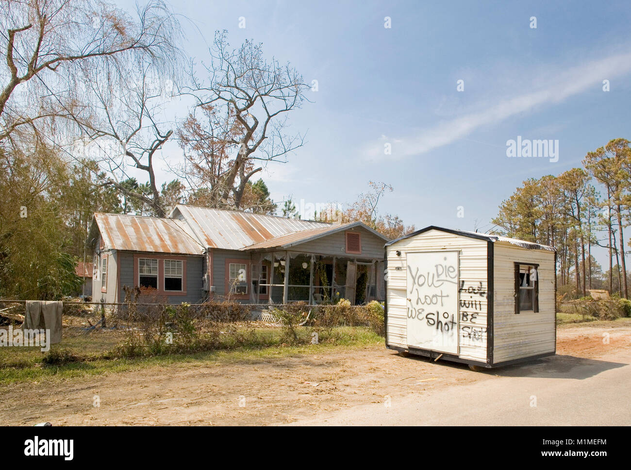 Un hangar de stockage en face d'une tempête maison endommagée. Le hangar a un message pour les pillards. 'Vous piller, nous pousse, mourir.' 'pilleurs sera tourné' ouragan Katr Banque D'Images