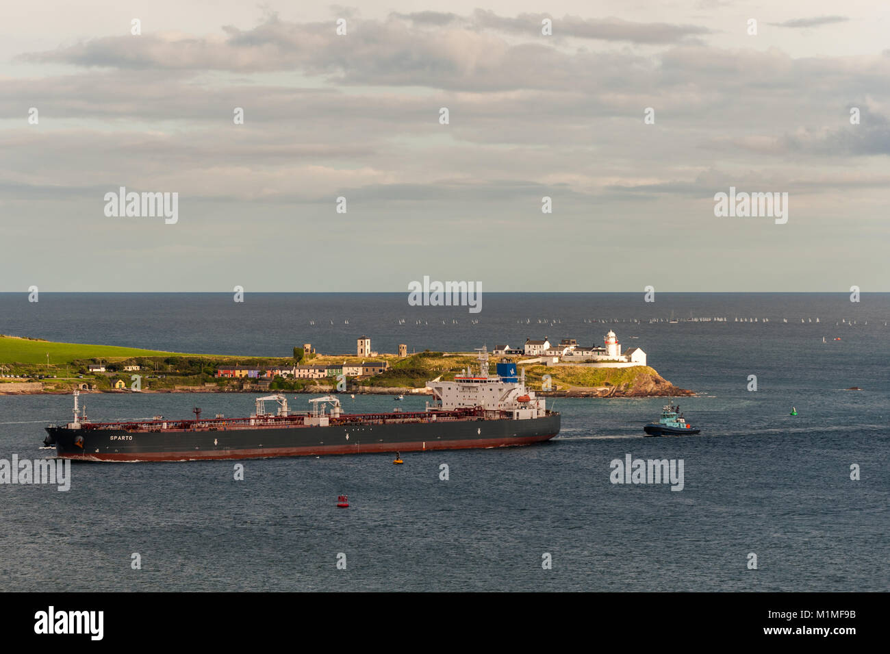 "Pétroliers parto' passe Roches Point Lighthouse, comté de Cork, Irlande sur son chemin à la raffinerie de pétrole Whitegate assistée par remorqueur 'Alex'. Banque D'Images