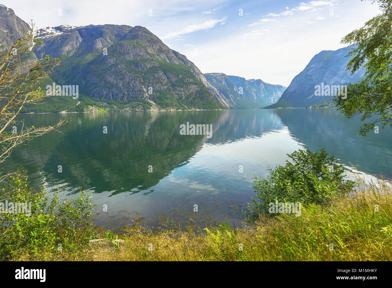 L'Eidfjorden réflexions avec près de village Eidfjord au bord de la mer sur la droite, Norvège, Scandinavie, fjord avec vue sur Simadalsfjorden Banque D'Images
