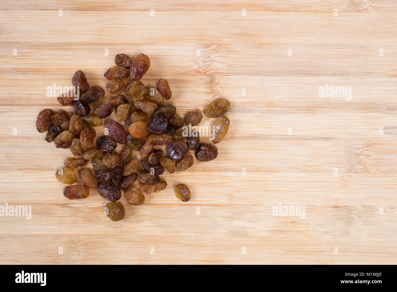 Tas de raisins secs sur une planche de bois. concept d'aliments sains Banque D'Images