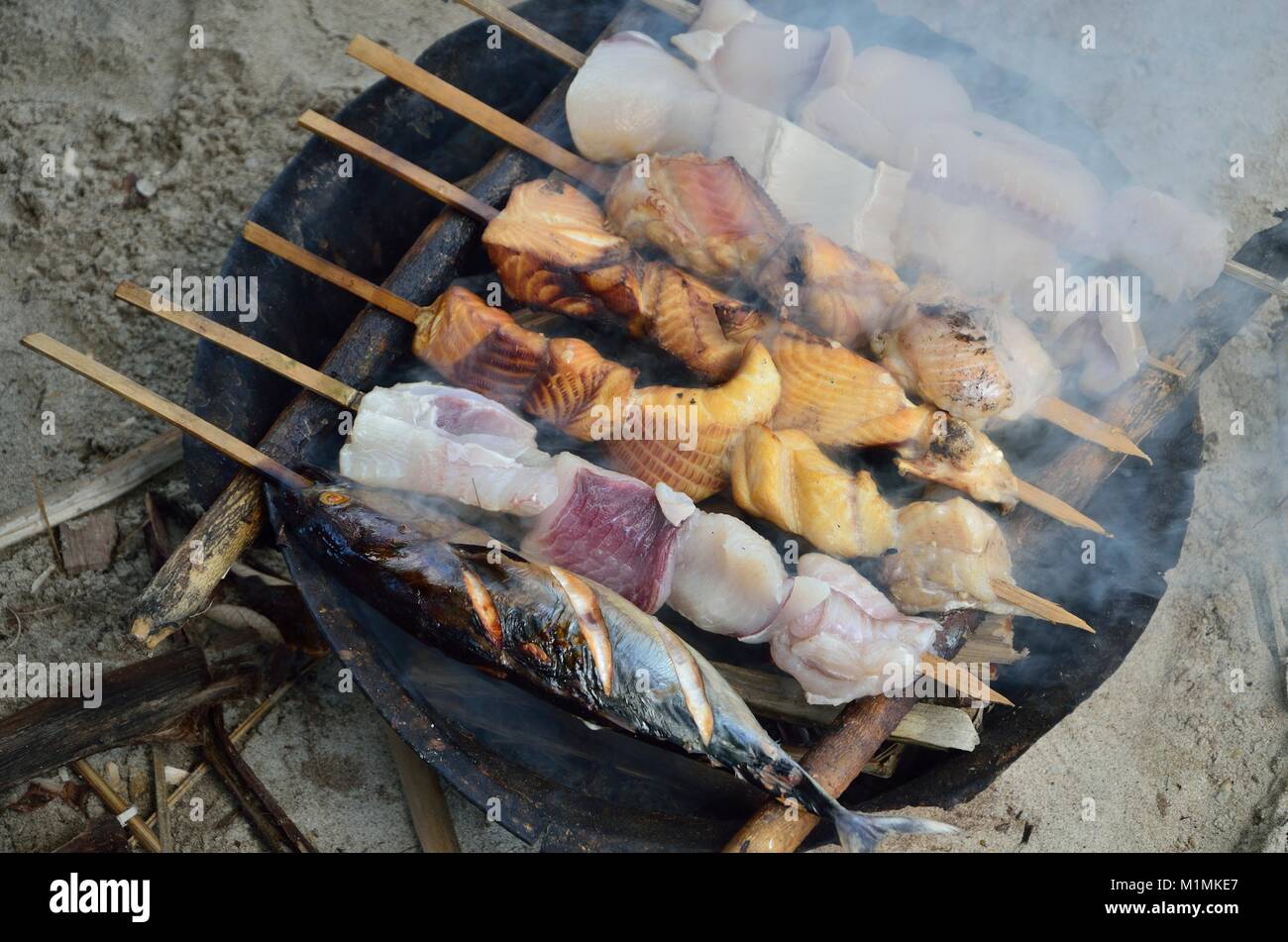 Brochettes de poisson cuisson sur un barbecue Banque D'Images