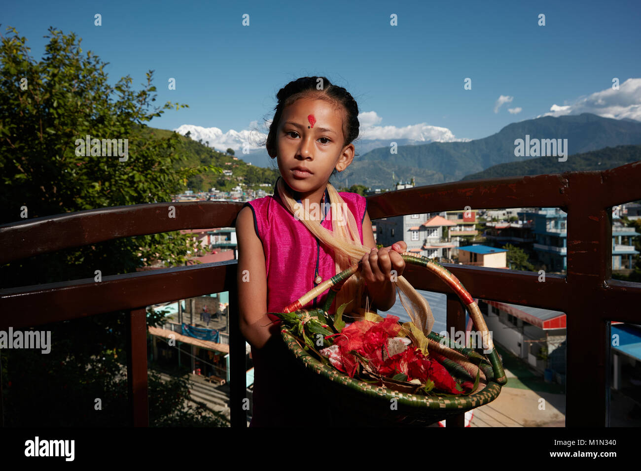 Jeune fille au Népal avec panier de fleurs Banque D'Images