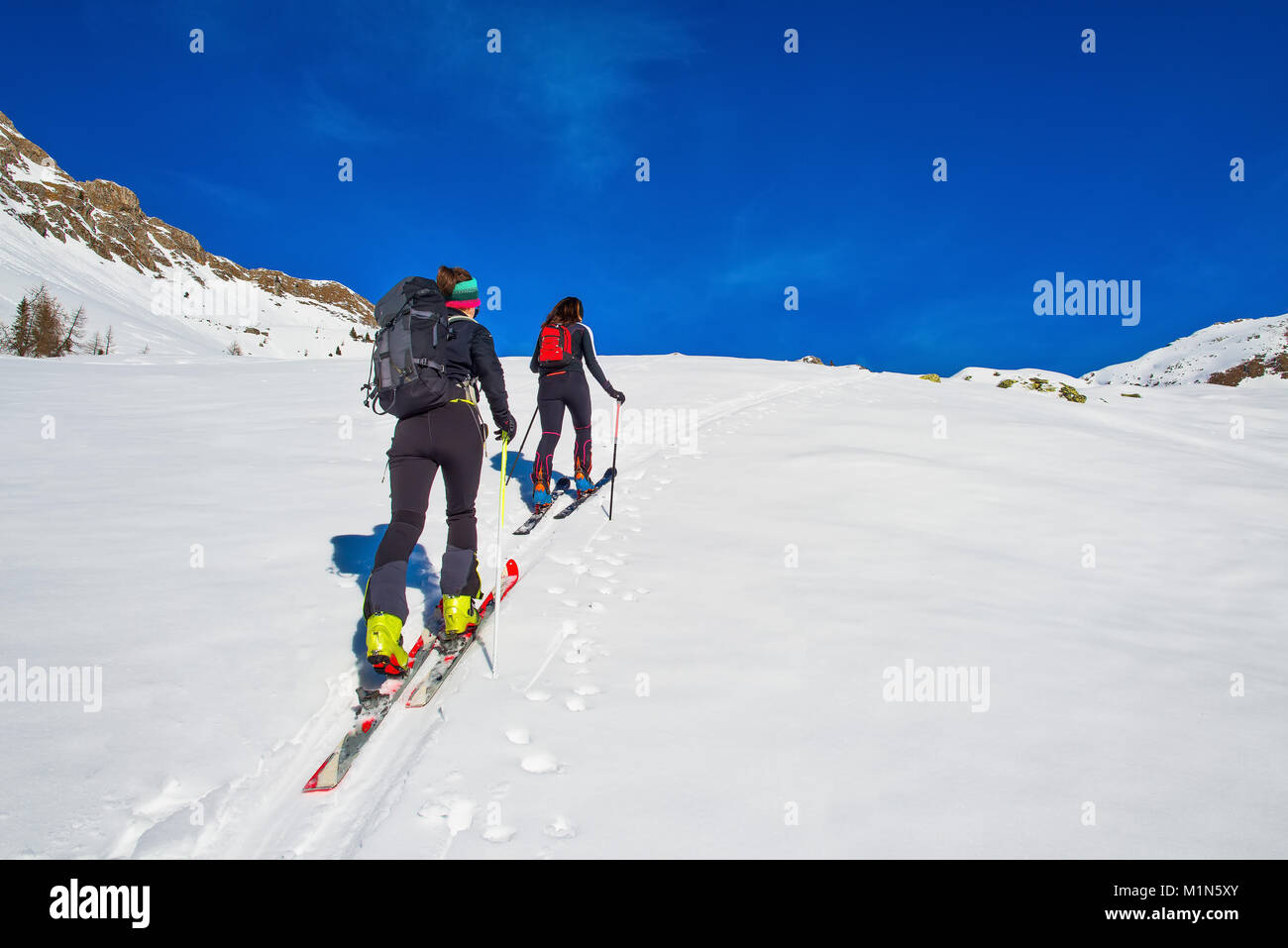 Deux filles de ski alpinisme en montée vers une montagne. Banque D'Images