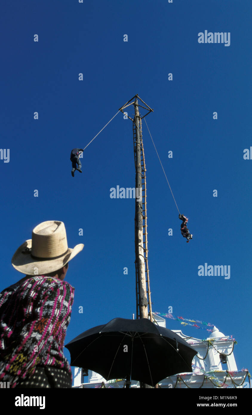 Le Guatemala. Chichicastenango. Fête religieuse annuelle de Saint Thomas le 21 décembre. Swinging Pole. 2 Les hommes commencent en haut de poteau et faire pivoter vers le bas. Banque D'Images