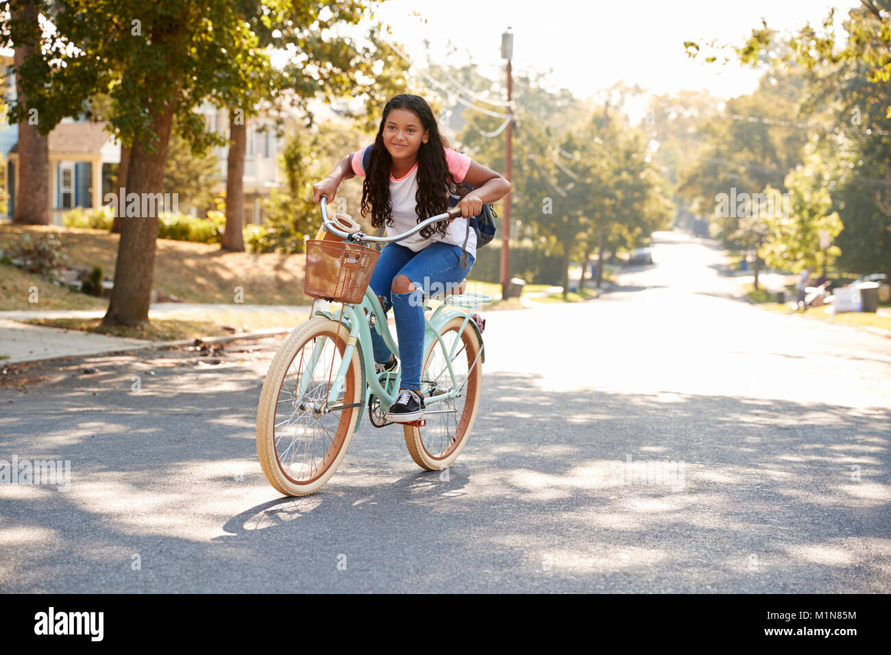 Girl Riding Bike dans cette rue à l'école Banque D'Images