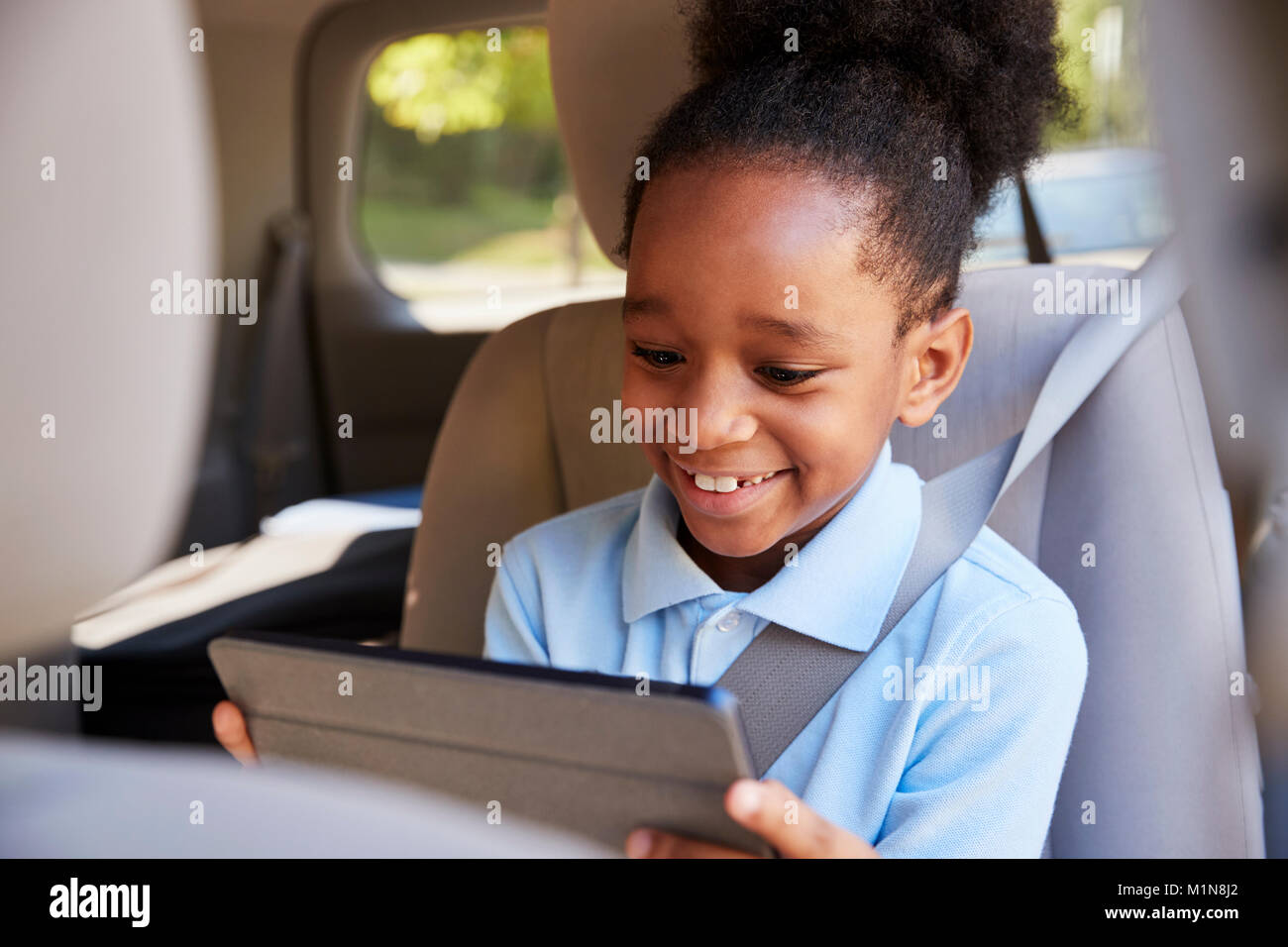 Boy Using Digital Tablet sur Voiture Banque D'Images
