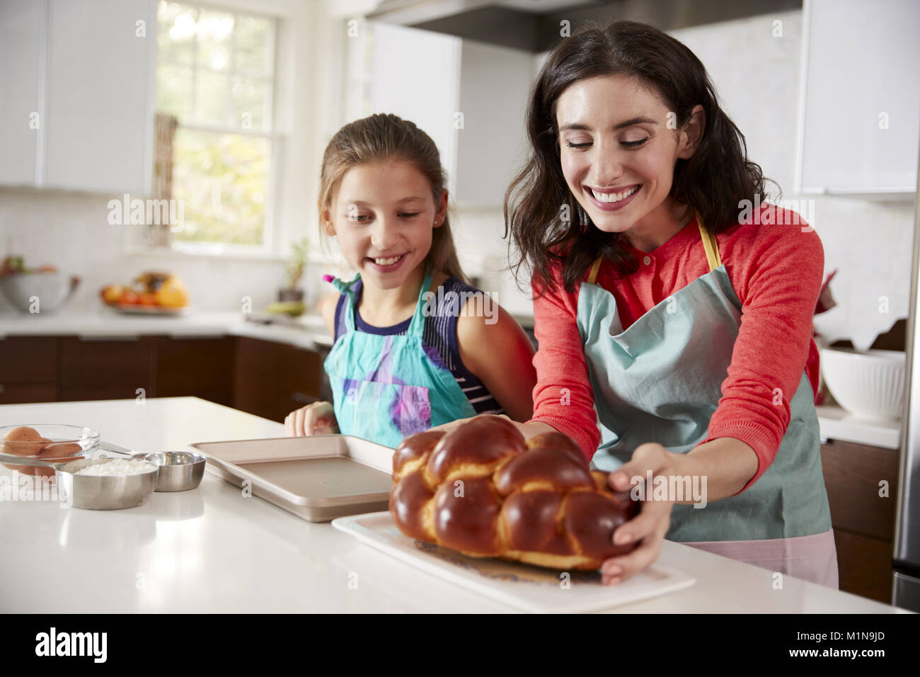 Mère et fille dans la cuisine avec du challah Banque D'Images