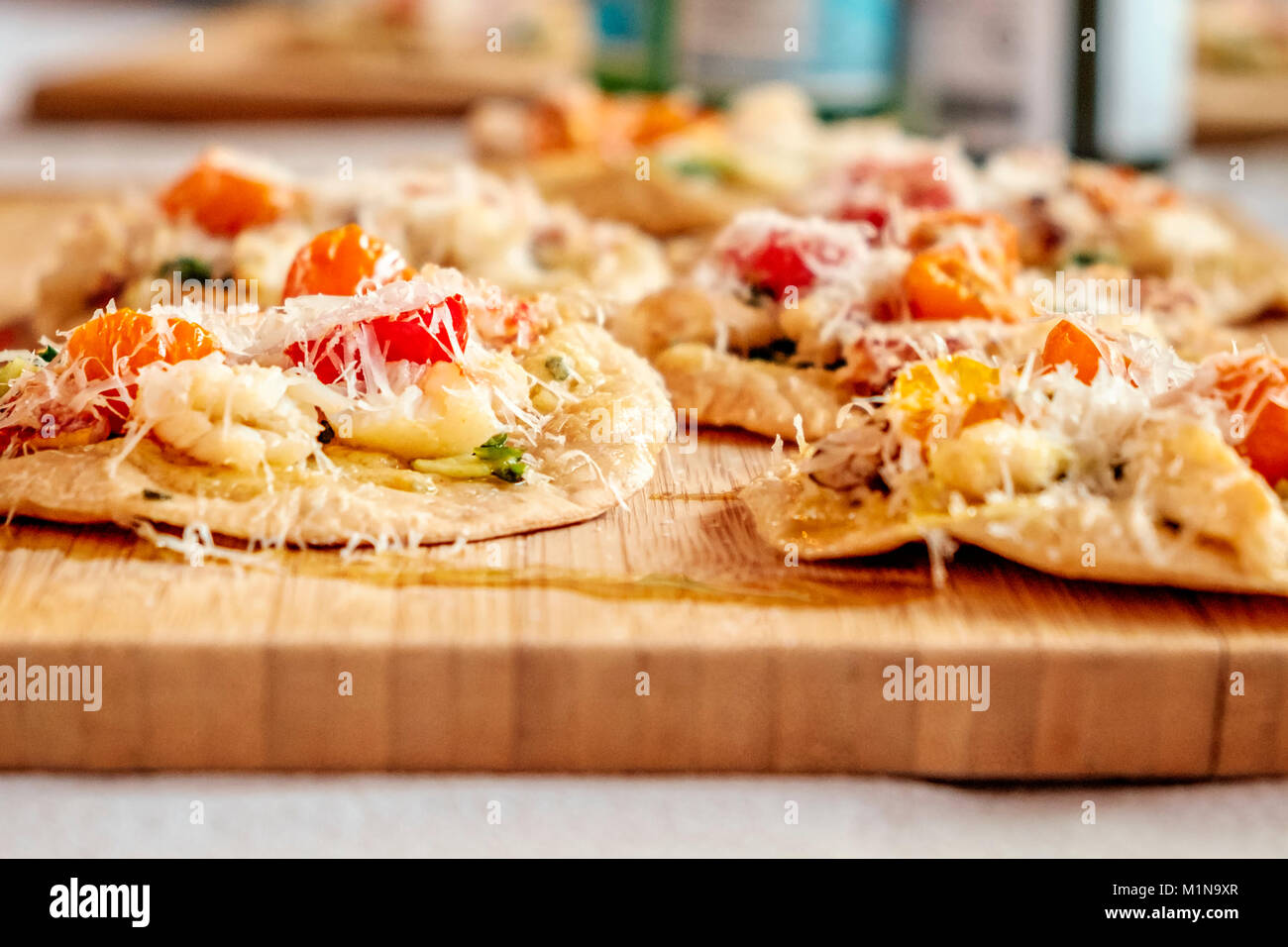 Pizzetta crabe (mini pizza) à la crème d'ail, roquette et tomates séchées demi-sungold Banque D'Images