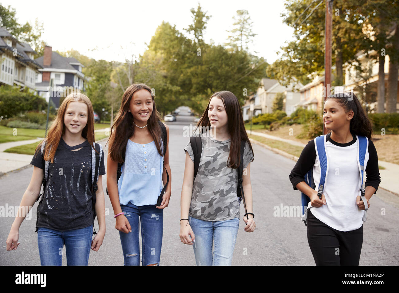 Quatre jeunes adolescentes marchant dans la route, Close up Banque D'Images