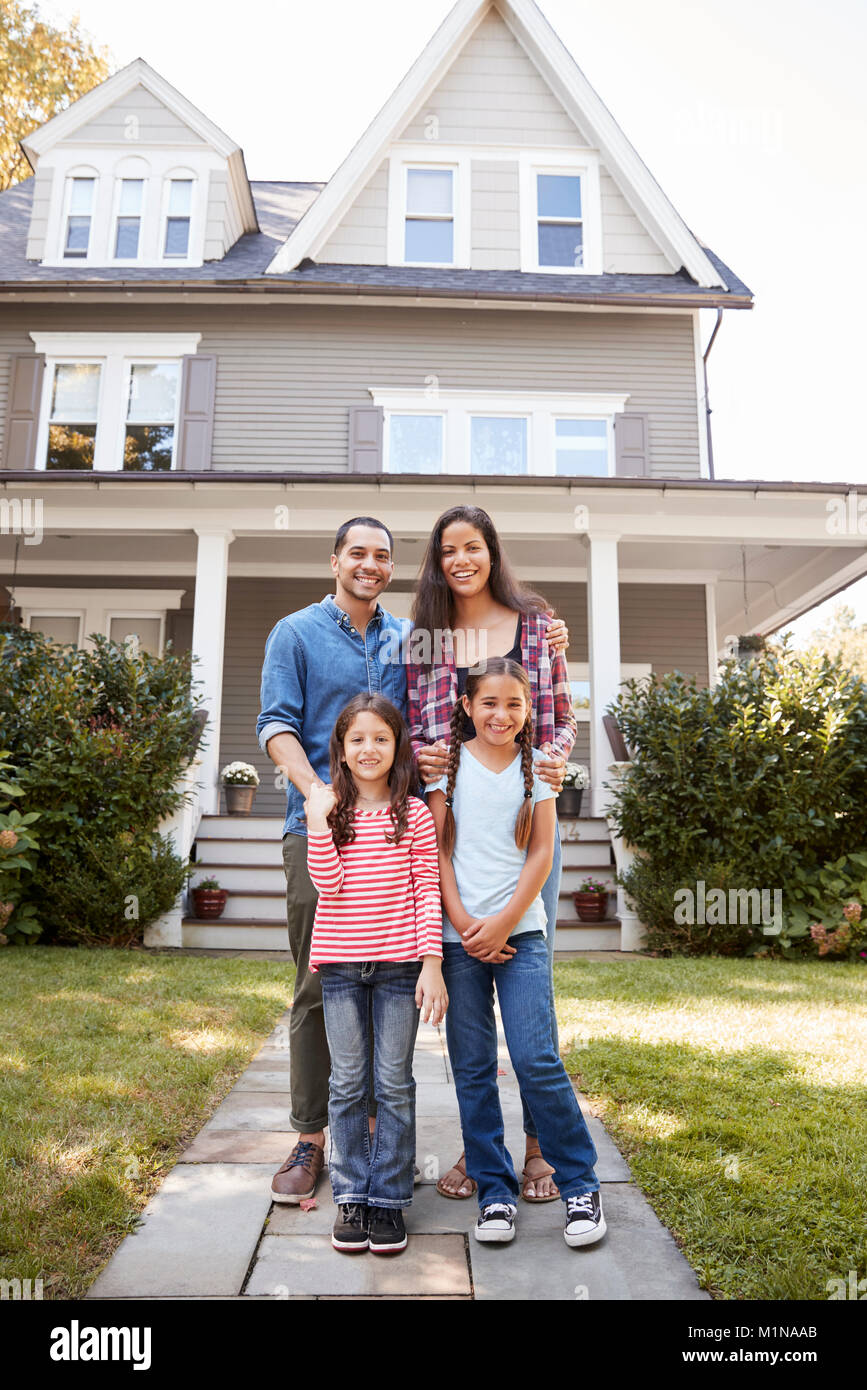 Portrait Of Smiling Family debout devant leur maison Banque D'Images