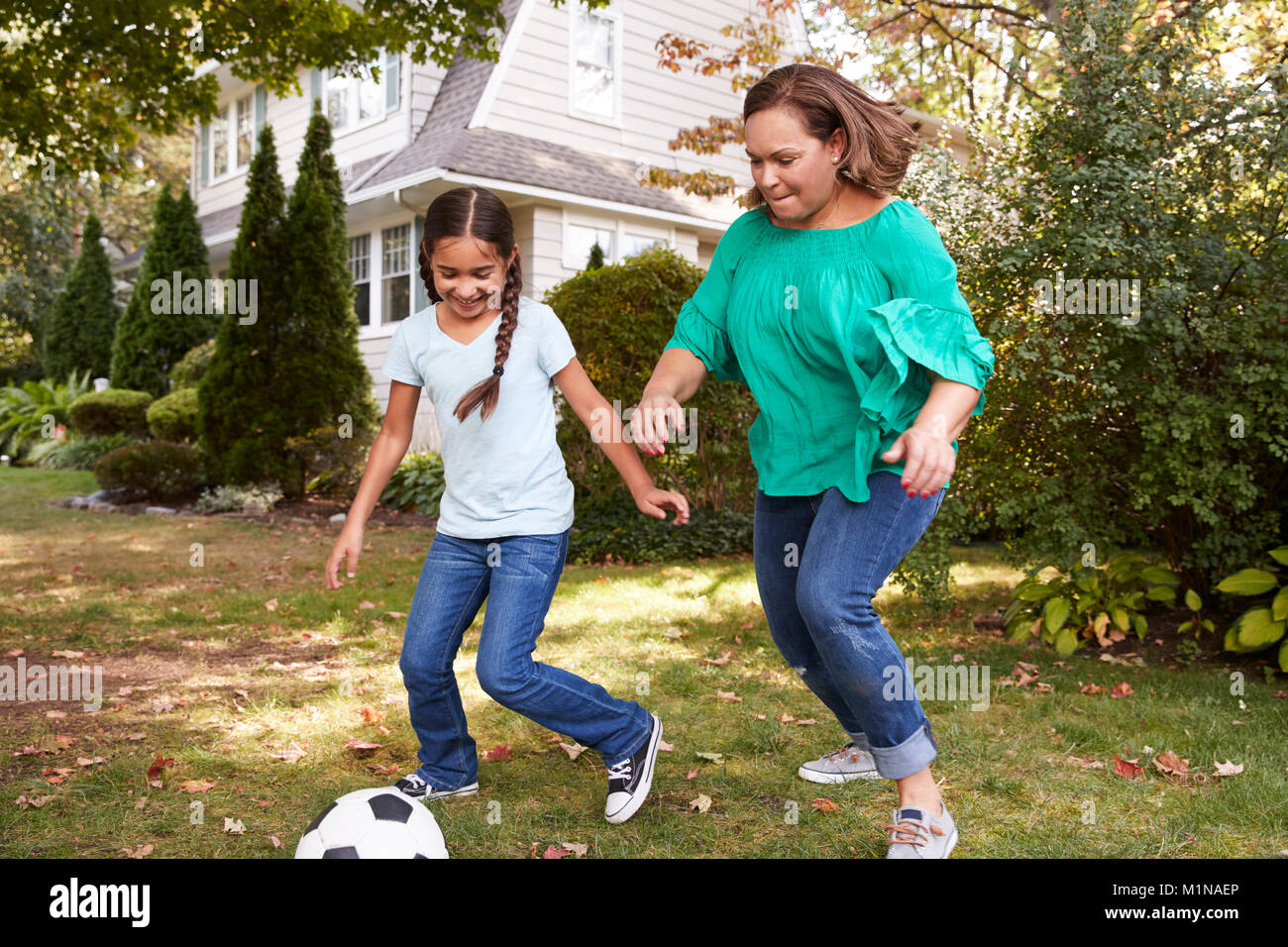 Grand-mère joue au soccer dans jardin avec petite-fille Banque D'Images