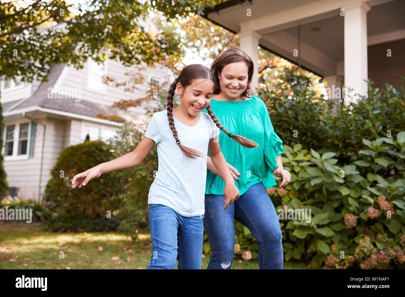 Grand-mère joue au soccer dans jardin avec petite-fille Banque D'Images