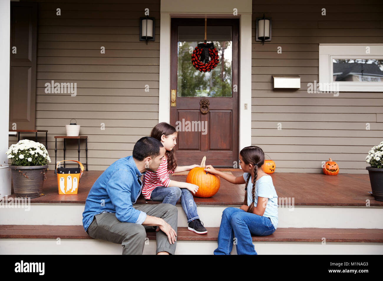 Père et filles face Dessin sur Halloween Citrouille Banque D'Images