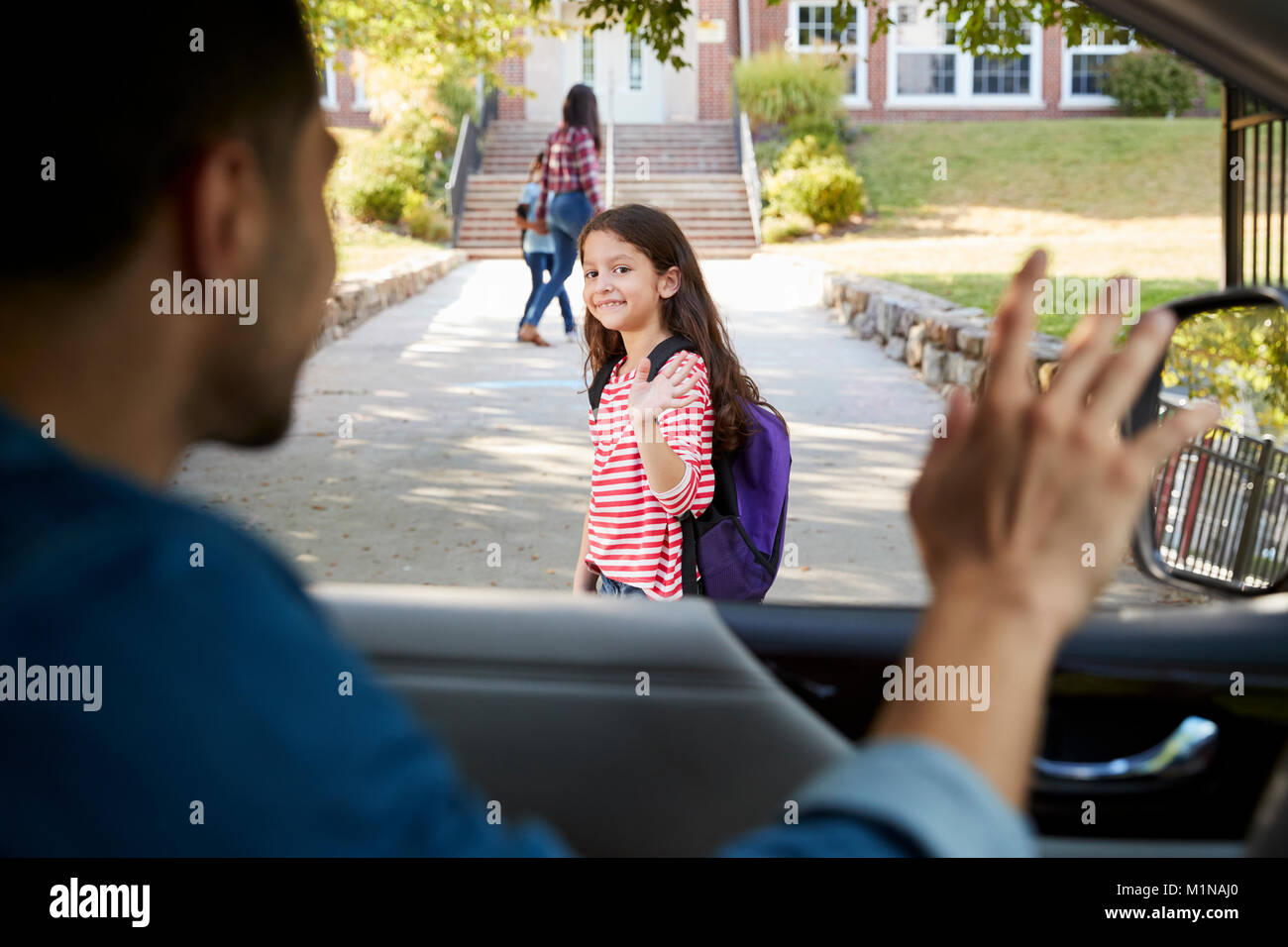 Père en voiture de tomber en face de fille d'école Banque D'Images