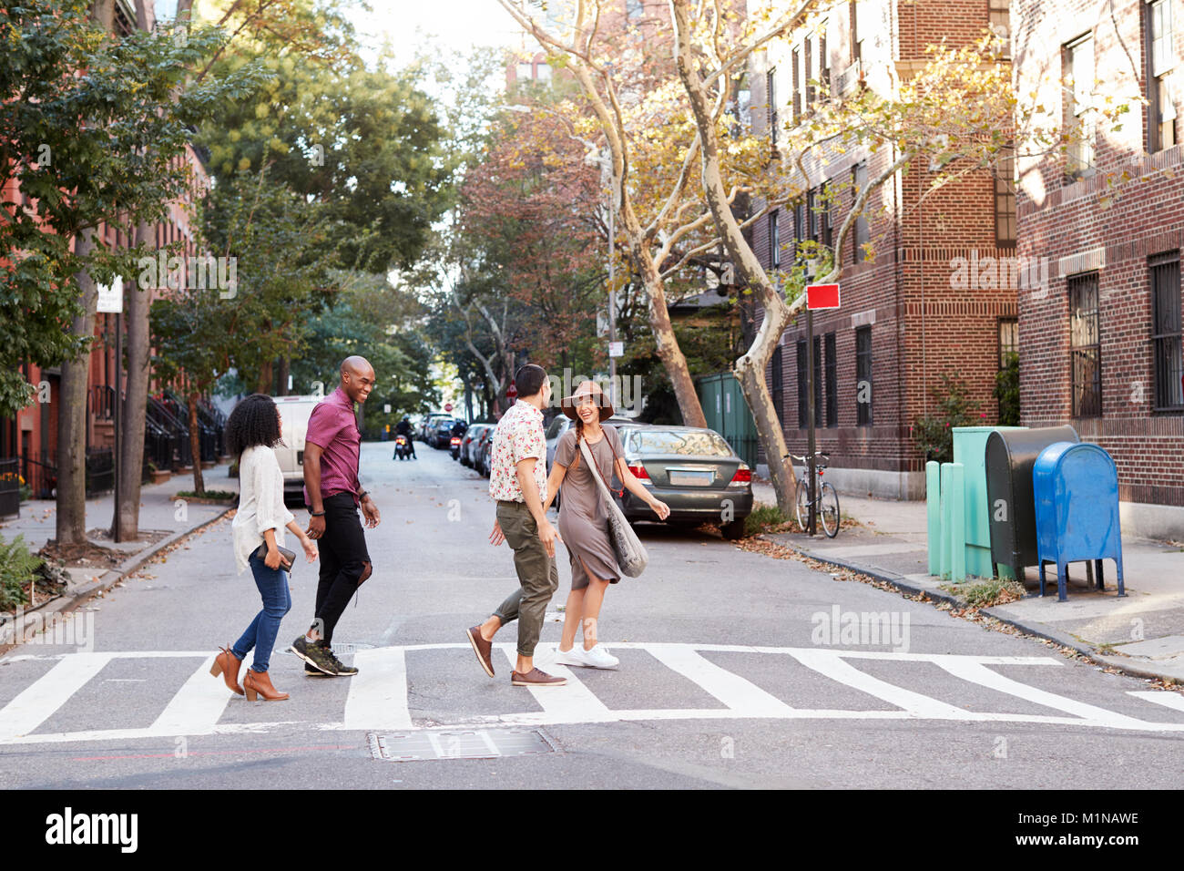 Groupe d'amis Crossing Urban Street à New York City Banque D'Images