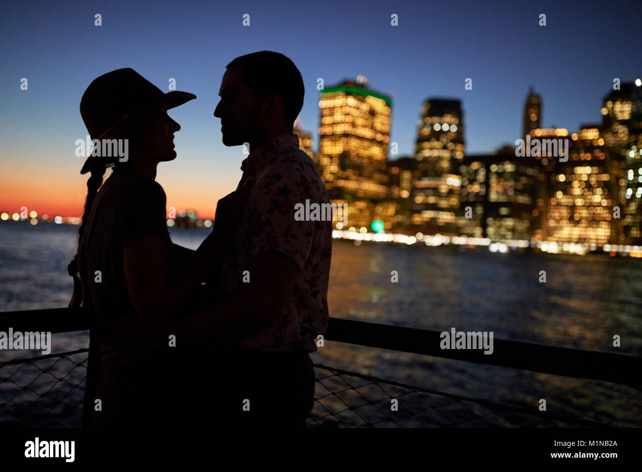 Silhouette Of Romantic Couple avec Ville en arrière-plan Banque D'Images