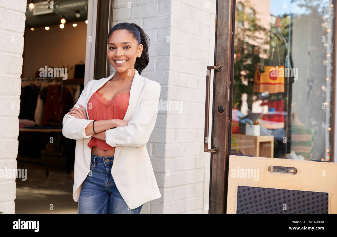 Young Hispanic businesswoman smiling to camera à l'extérieur de sa boutique Banque D'Images