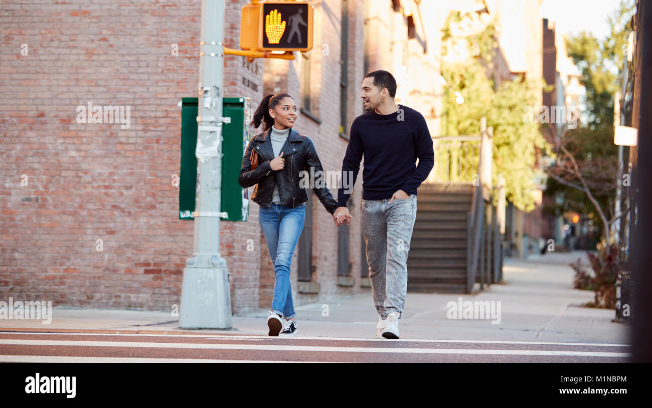 Young Hispanic couple marche main dans la main à Brooklyn Banque D'Images