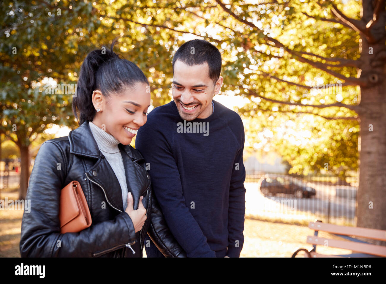 Young Hispanic couple marche main dans la main dans la région de Brooklyn Park Banque D'Images