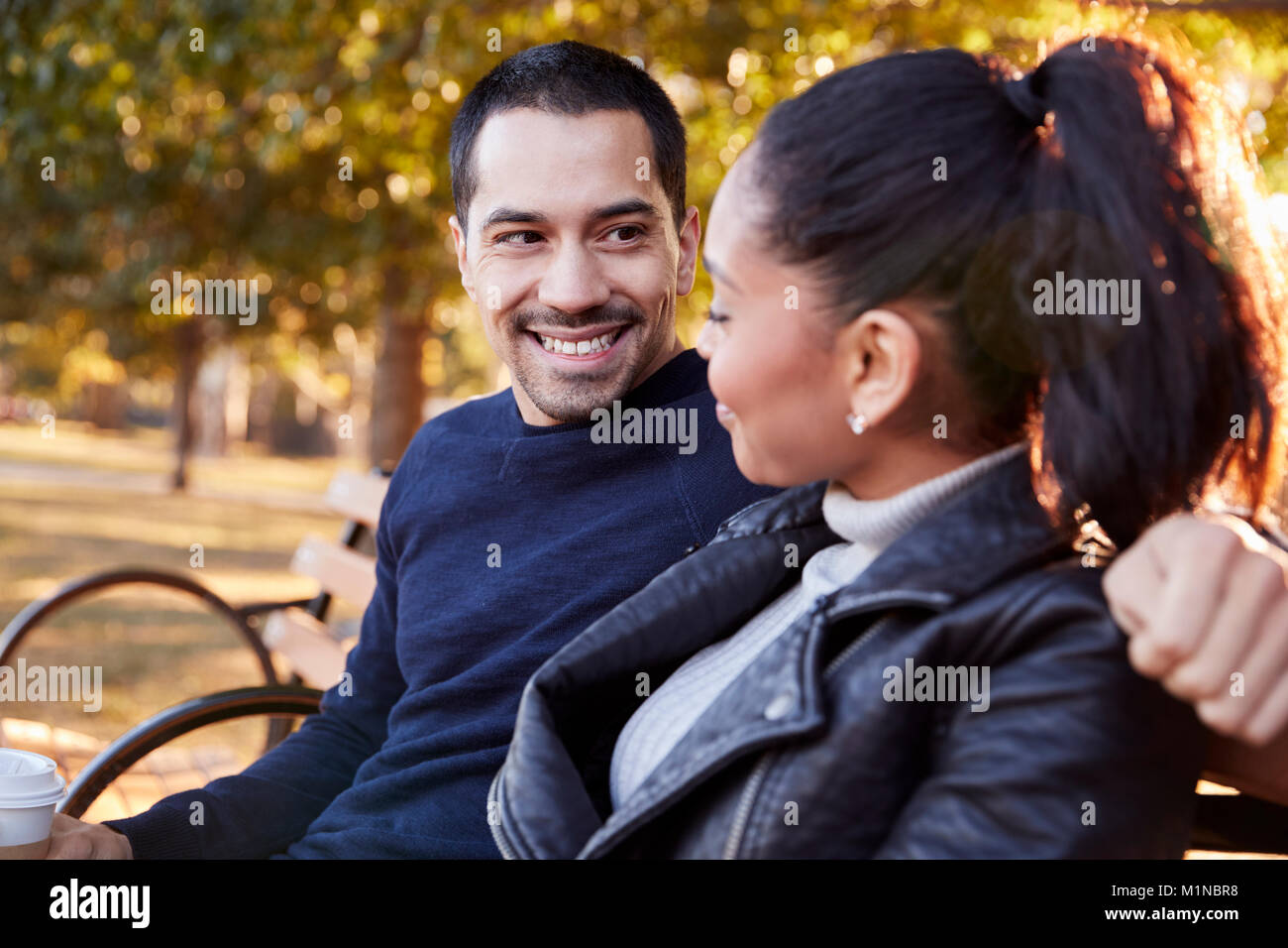 Jeune couple assis sur un banc à Brooklyn Park, Close up Banque D'Images