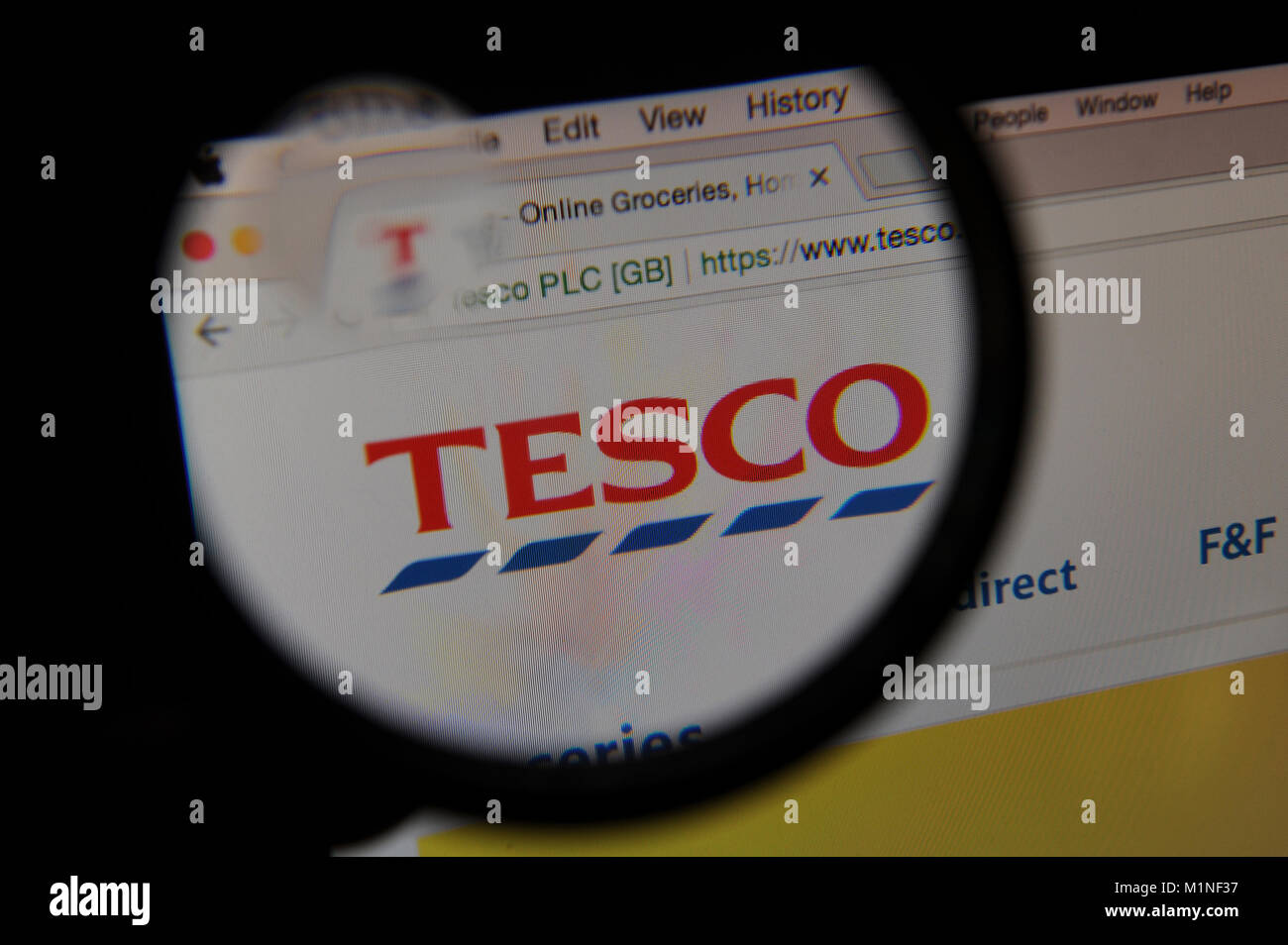 Le site web de supermarché Tesco est vu à travers une loupe Banque D'Images