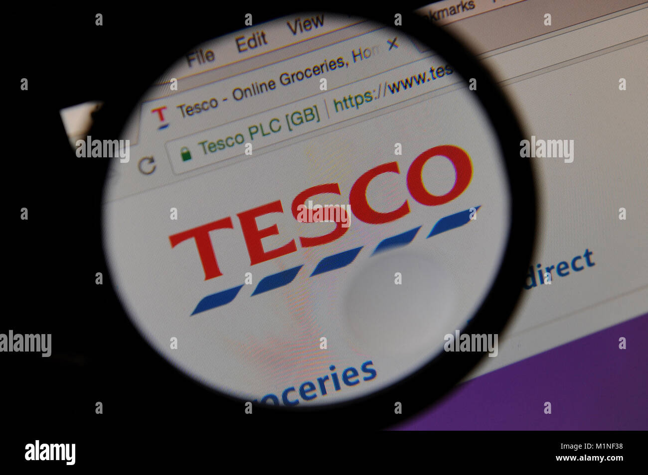 Le site web de supermarché Tesco est vu à travers une loupe Banque D'Images