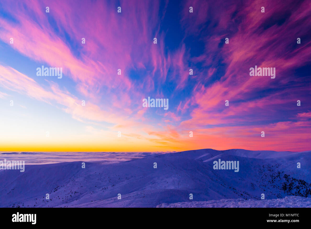 Incroyable coucher de soleil colorés dans les montagnes avec des nuages de forme ailes absract Banque D'Images