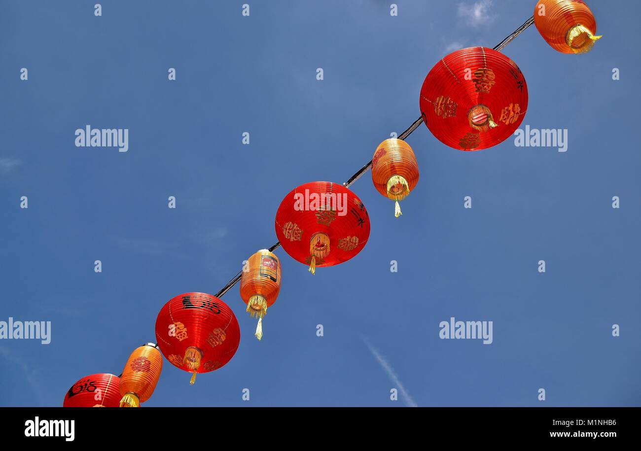 Une chaîne de lampions rouges traditionnels isolés contre un ciel bleu célébrant le Nouvel An lunaire dans Chinatown, Singapour Banque D'Images
