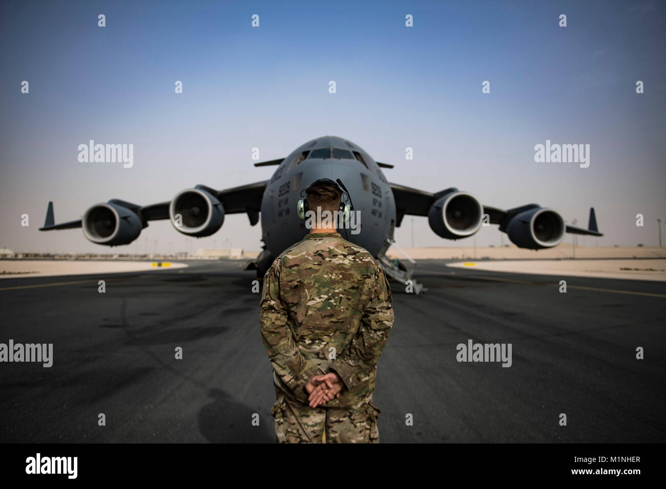 Un U.S. Air Force C-17 Globemaster III, membre de l'équipe d'entretien au sol affecté à l'expéditionnaire 816th Escadron de transport aérien, est sur le point de donner des directives à un C-17 pilote à la base aérienne d'Al Udeid, Qatar, le 22 janvier 2018. Le personnel de maintenance sont responsables d'assurer la sécurité et la fonction de tous les systèmes de l'aéronef pour délivrer une capacité de transport aérien stratégique rapide dans tout le commandement central des États-Unis. (U.S. Air Force Photo de Tech. Le Sgt. Gregory Brook) Banque D'Images