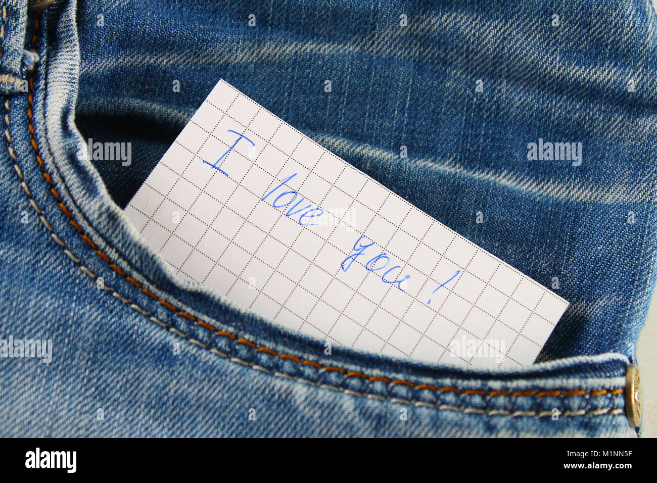 Note papier avec l'inscription je t'aime, avec l'amour piaulements de la poche de jean. Le concept de la journée des amoureux. La Saint-Valentin Banque D'Images