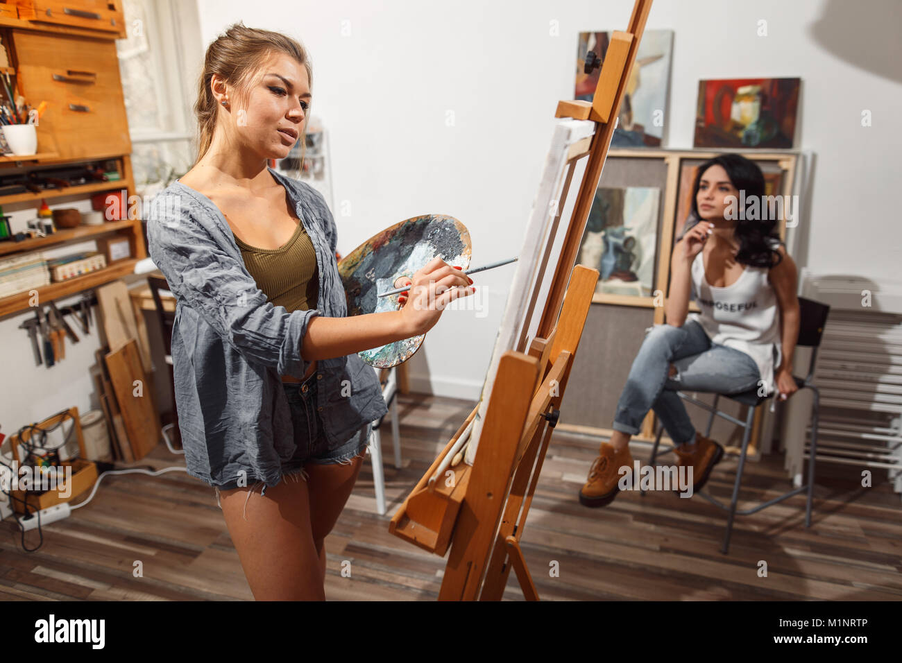 Deux filles dans un studio d'artiste Peintures model. Banque D'Images