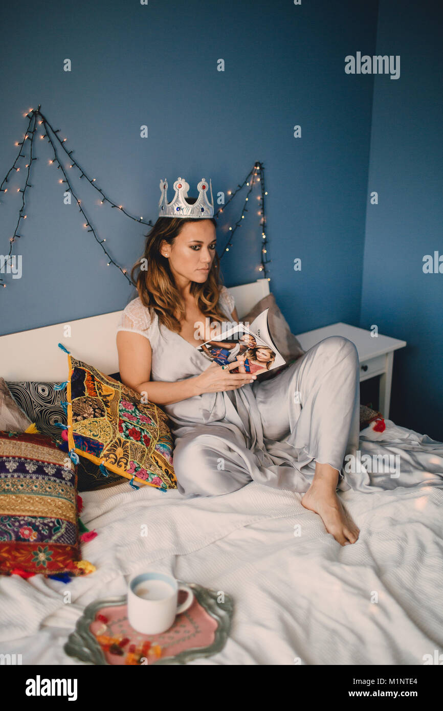 La jeune fille avec la couronne allongée sur le lit dans la chambre, Banque D'Images