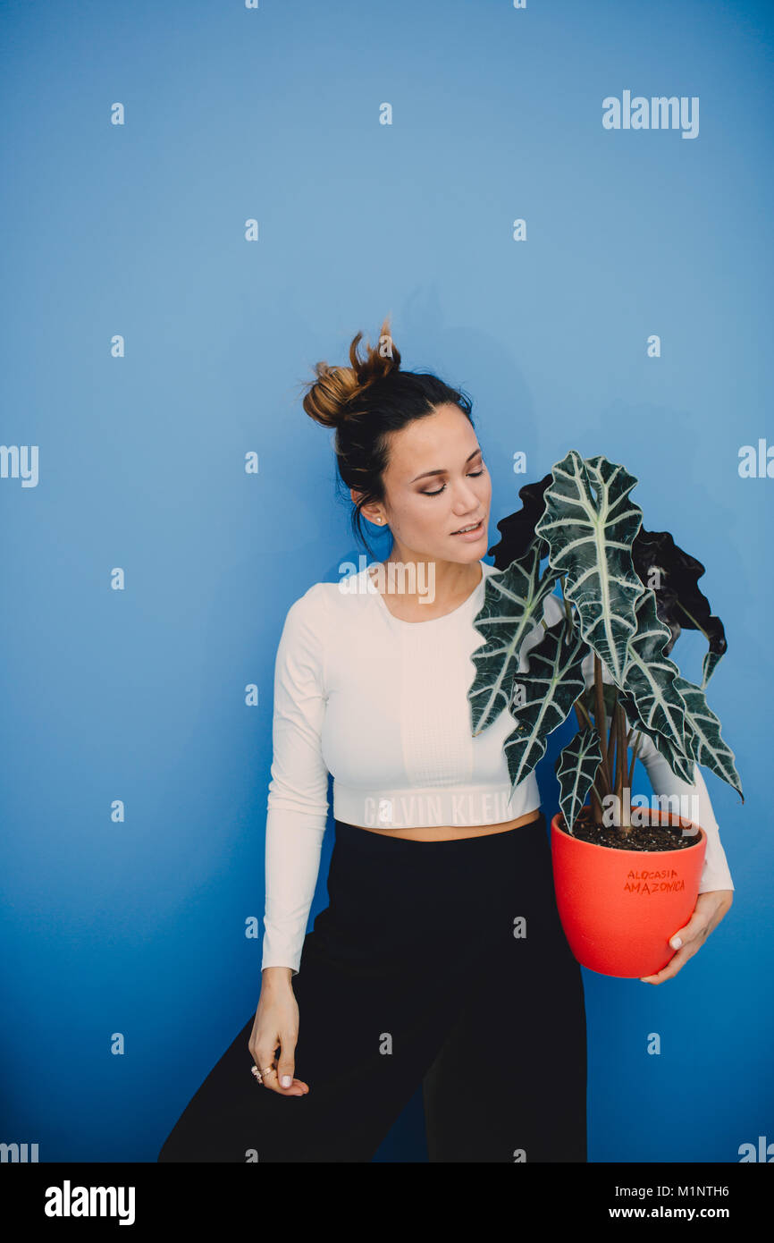 Portrait de belle fille de la mode avec des plantes sur fond bleu Banque D'Images